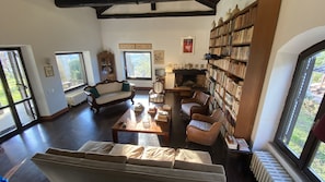 Ein geräumiges Wohnzimmer mit einer großen Bücherwand, einem Kamin und einer gemütlichen Sitzecke.