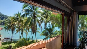 A balcony with terracotta tiles overlooking a tropical beach with palm trees and a clear blue sea. - Wonderful house by the water in Angra dos Reis. (Angra dos Reis)