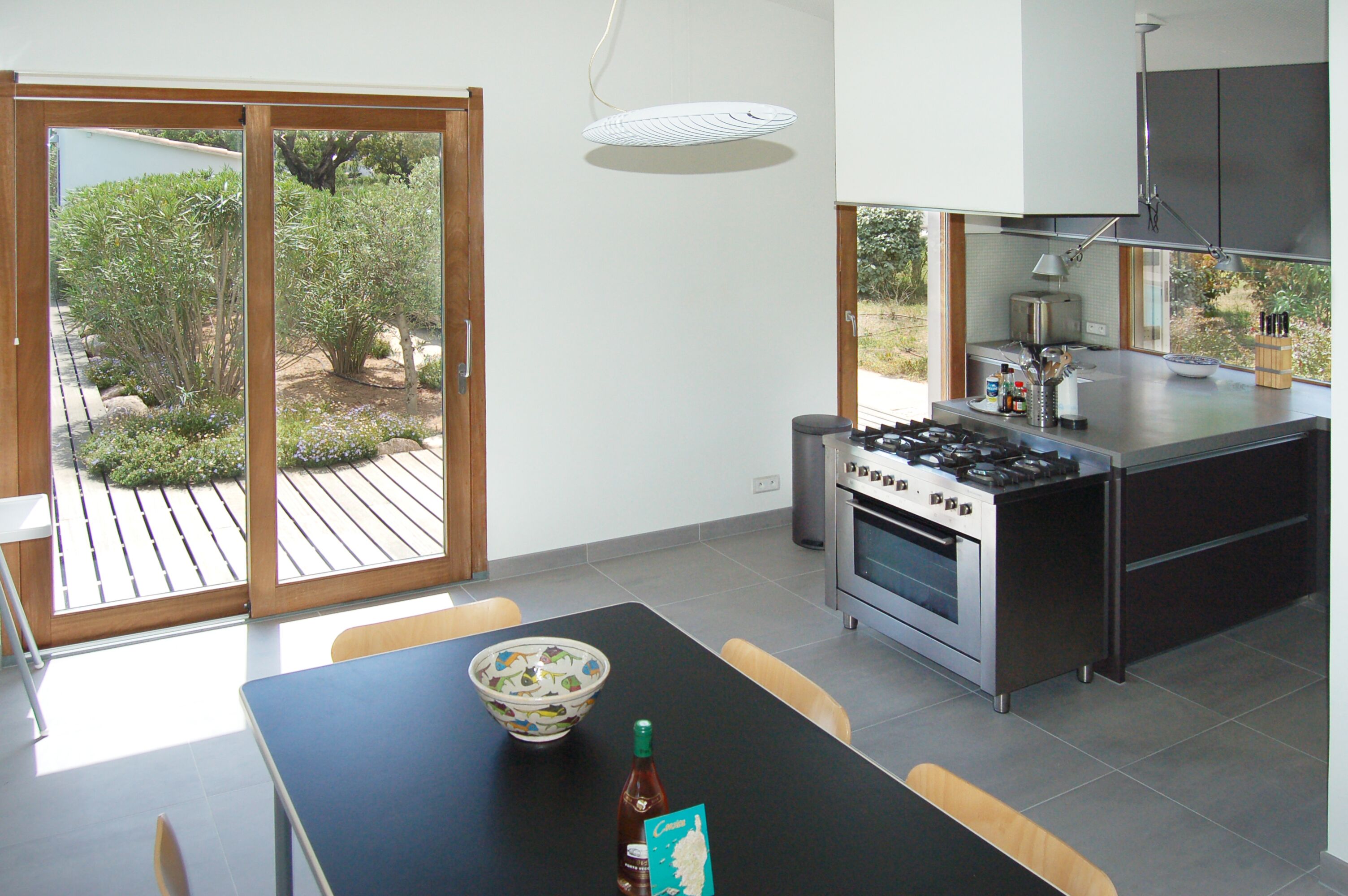 Una cocina moderna con estufa a gas, horno y un comedor con mesa y sillas.