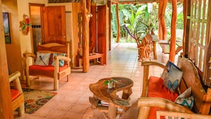 A wooden-floored room with a covered area, wooden furniture, and a view of greenery outside. - Casa Del Caribe with Bali Style Pool for Rent in Cocles, 300 meters from beach (Cocles)