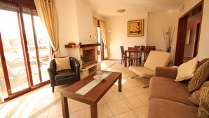 Una sala de estar con sofá, una mesa de centro y un comedor con sillas y una mesa.