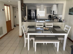 Enjoy meals in the spacious kitchen and dining area, featuring a large island and comfortable seating.