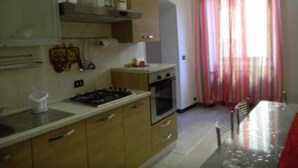 Una cocina compacta con armarios de madera, una estufa a gas y un horno pequeño.