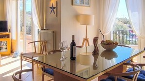 A dining area with a glass table, wooden chairs, a bowl of fruit, a wine bottle, and a lamp. - Luxurious and family friendly villa with large private pool 5 mins from Skiathos (Skiathos)