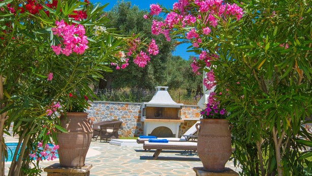 A stone pathway leading to a pool area with a barbecue setup and outdoor seating. - Luxurious and family friendly villa with large private pool 5 mins from Skiathos (Skiathos)