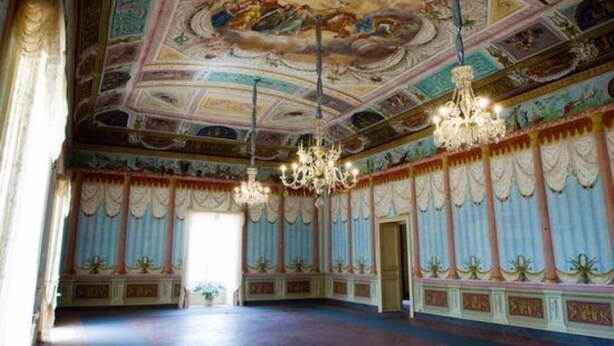 Un vaste hall orné de fresques au plafond, de lustres et de colonnes de style classique.