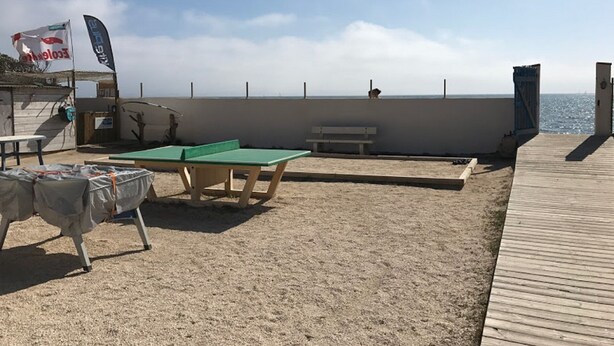 A beachside area with a ping pong table, a bench, and a covered table. - Blue Wave Studio - Hyères - Waterfront Residence - Giens Peninsula (Hyères)