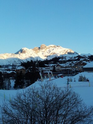 A snow-covered mountain with a ski resort in the foreground.