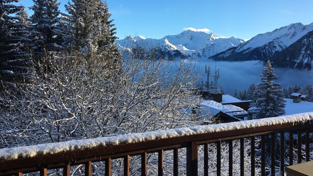 A snow-covered mountain landscape with a clear sky, a wooden balcony railing, and a cabin in the background. - COURCHEVEL 1850 RESIDENCE CHALET STYLE - BEAUTIFUL VIEW ON MASSIF DE LA VANOISE (Courchevel)