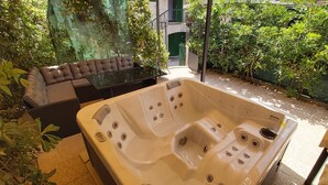 A spa area with a hot tub, a cushioned seating area, and lush greenery. - Romantic Apartment Johnny I, hot tub in garden, Studio in Split center, Croatia  (Split)