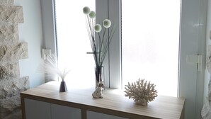 A wooden console table with decorative items including a vase with spherical objects, a white sculpture, and a feather arrangement. - Romantic Apartment Johnny I, hot tub in garden, Studio in Split center, Croatia  (Split)