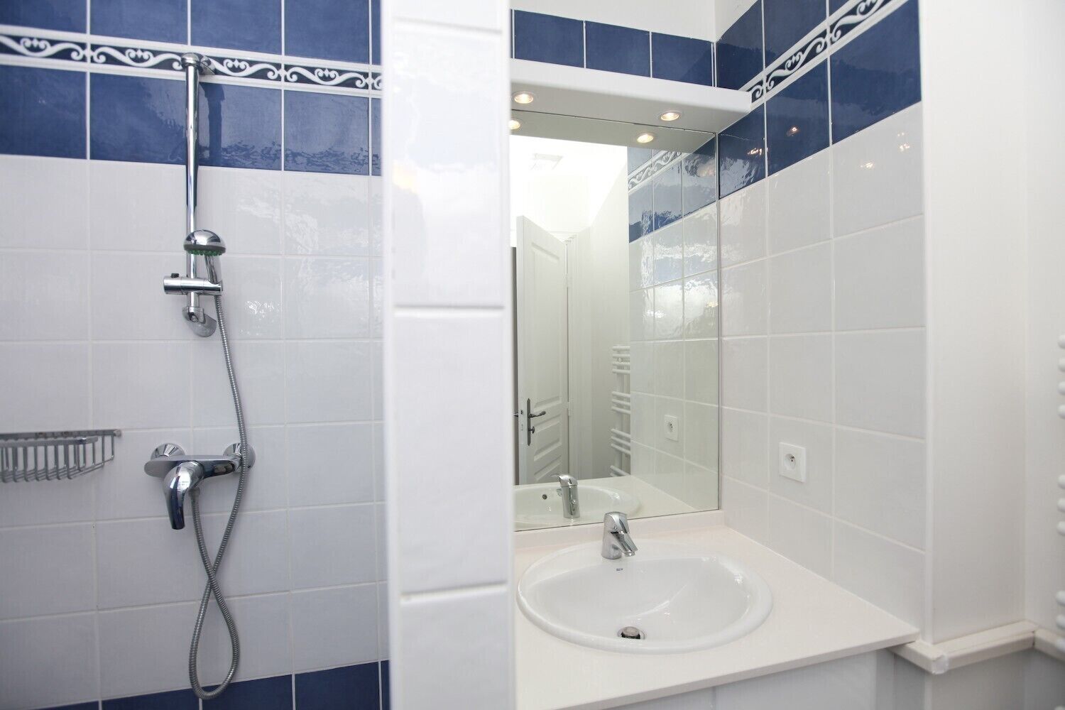 A bathroom with a shower, a sink, and a mirror.