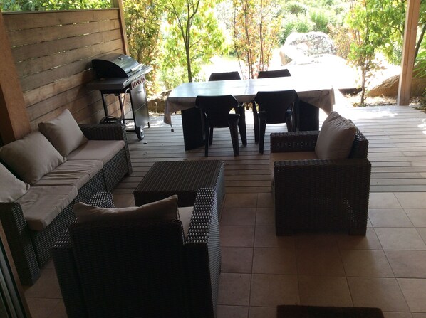 An outdoor patio with wicker furniture, a grill, and a table. - Walk-new in charming residence with 300m² swimming pool in Porto Vecchio (Porto-Vecchio)