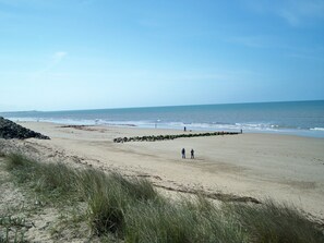 A beach with a rocky barrier and sparse vegetation. - For all your hollidays (Saint-Hilaire-De-Riez)