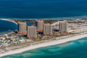A high-rise hotel complex with multiple buildings, a beach, and a marina.