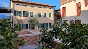 A building with multiple windows and a small tree in the courtyard. - Asolo center, Free parking  (Asolo)