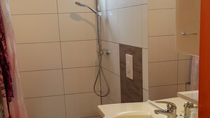 A modern bathroom with a shower, toilet, and sink. - Gezellig vakantiehuisje vlakbijhet Grevelingenmeer, huisdieren toegestaan. (Holland)