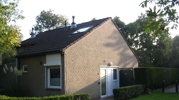 A single-story house with a sloped roof, a front door, and a small window. - Gezellig vakantiehuisje vlakbijhet Grevelingenmeer, huisdieren toegestaan. (Holland)