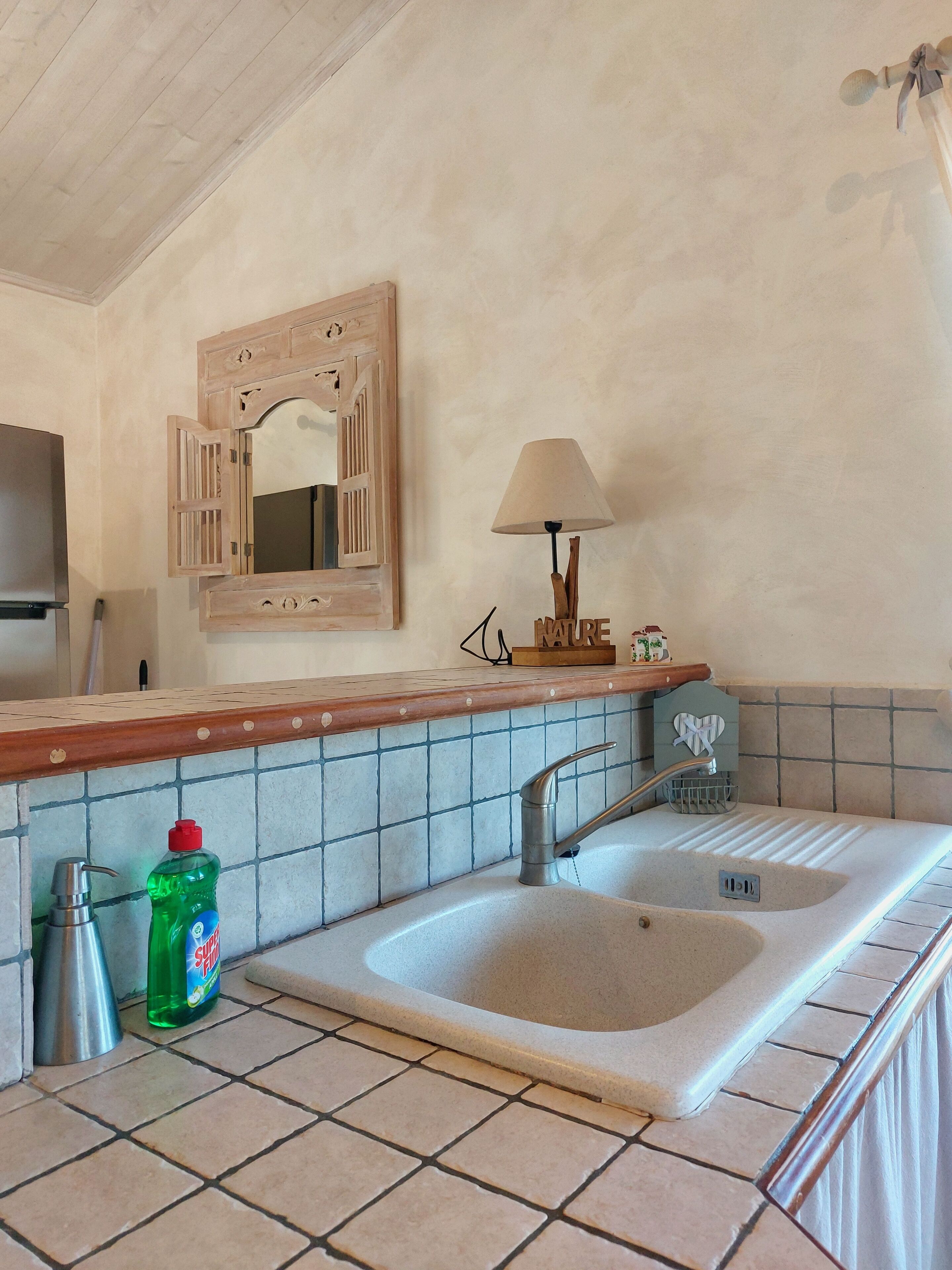 A bathroom with a sink, mirror, and a towel rack.