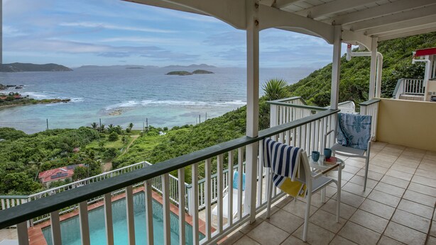 A balcony with a view of a pool and ocean. - Casa de Suenos | St. John (Coral Bay)