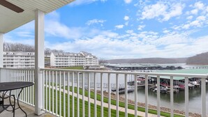 A balcony with a view of a marina, a large hotel building, and a green sports court. -  Parkview Bay 616, Book NOW for the SHOOTOUT RACE, VERY CLOSE TO RACE (Osage Beach)
