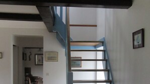 Eine Treppe mit blauer Handlauf, die zu einer Zwischenebene führt.
