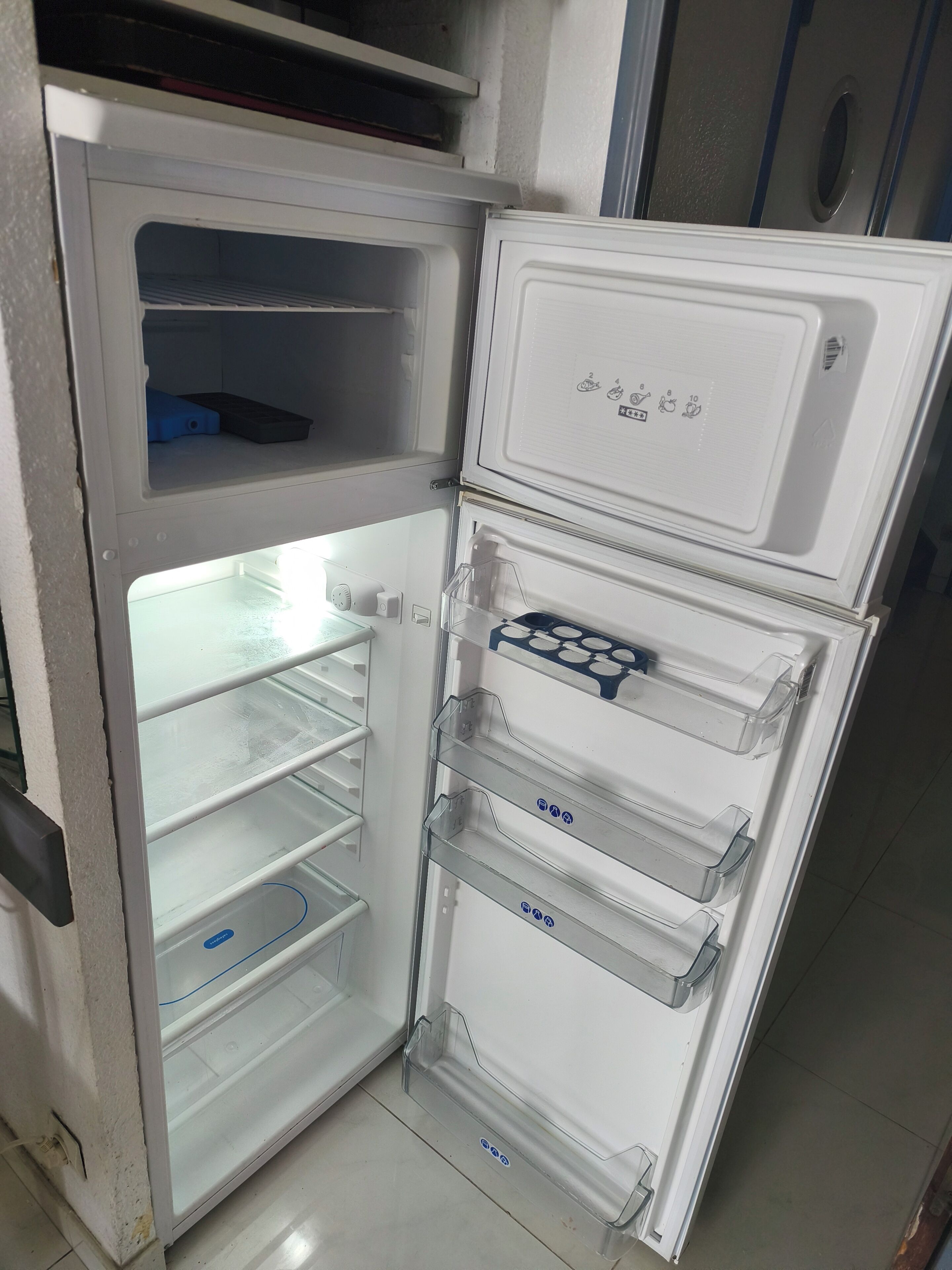 An open refrigerator with multiple shelves and a freezer compartment.