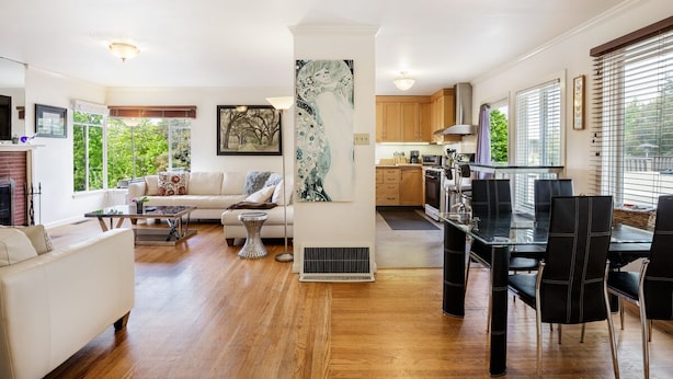 A spacious living area with a sofa, coffee table, and a dining table with chairs. There is a kitchen area with cabinets and a stove. - 2 Bedroom Condo Only 1 Block to UCB (Berkeley)