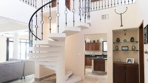 Ein geräumiger Wohnbereich mit moderner Treppe, einer Küche und einem Essbereich.