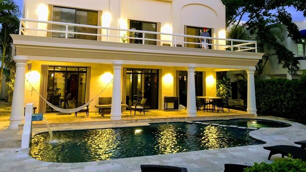 Ein zweistöckiges Gebäude mit Pool und Außenbereich.