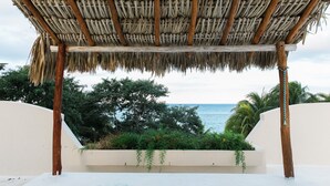 Ein Gebäude mit einem Reetdach und Blick auf das Meer.