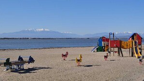 Ein Strand mit Spielgeräten und einer Wippe.