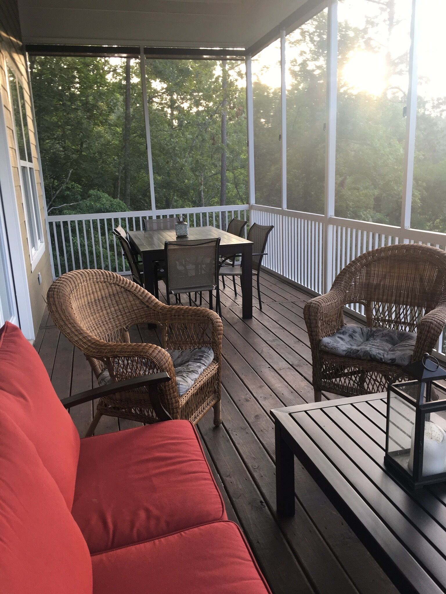 Outdoor seating on screened porch with outdoor dining area