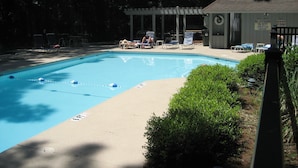 Una piscina amb gandules i un pavelló.
