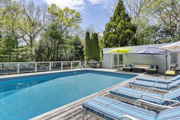 huge swimming pool and deck surrounded by trees