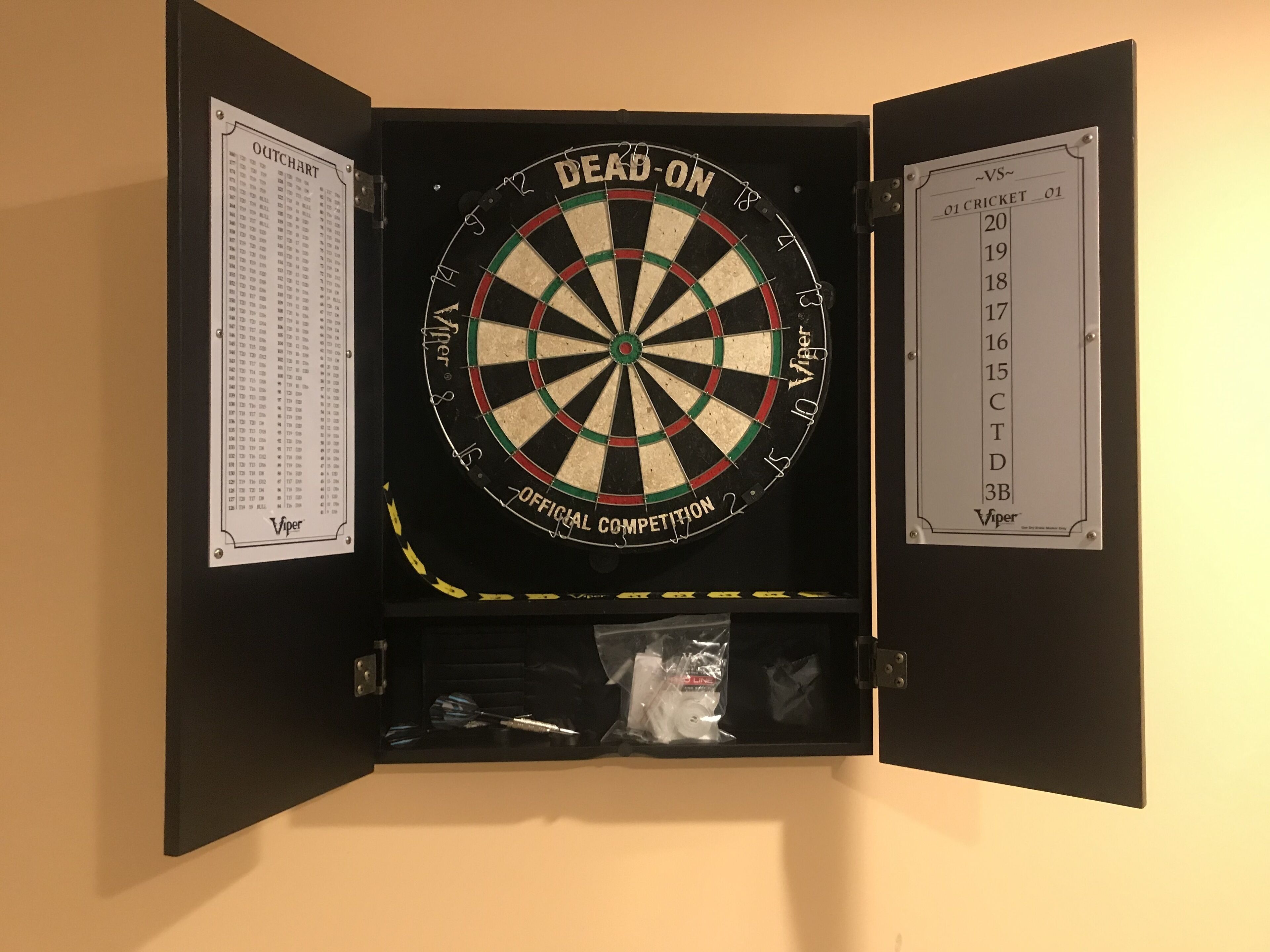 Un jeu de fléchettes avec un tableau de pointage et une liste de noms.