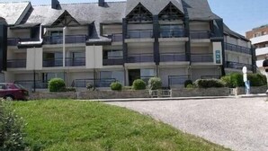 A multi-story hotel with a modern architectural design, featuring balconies and a central courtyard. - Apartment in quiet residence facing the beach with sea view (Quiberon)