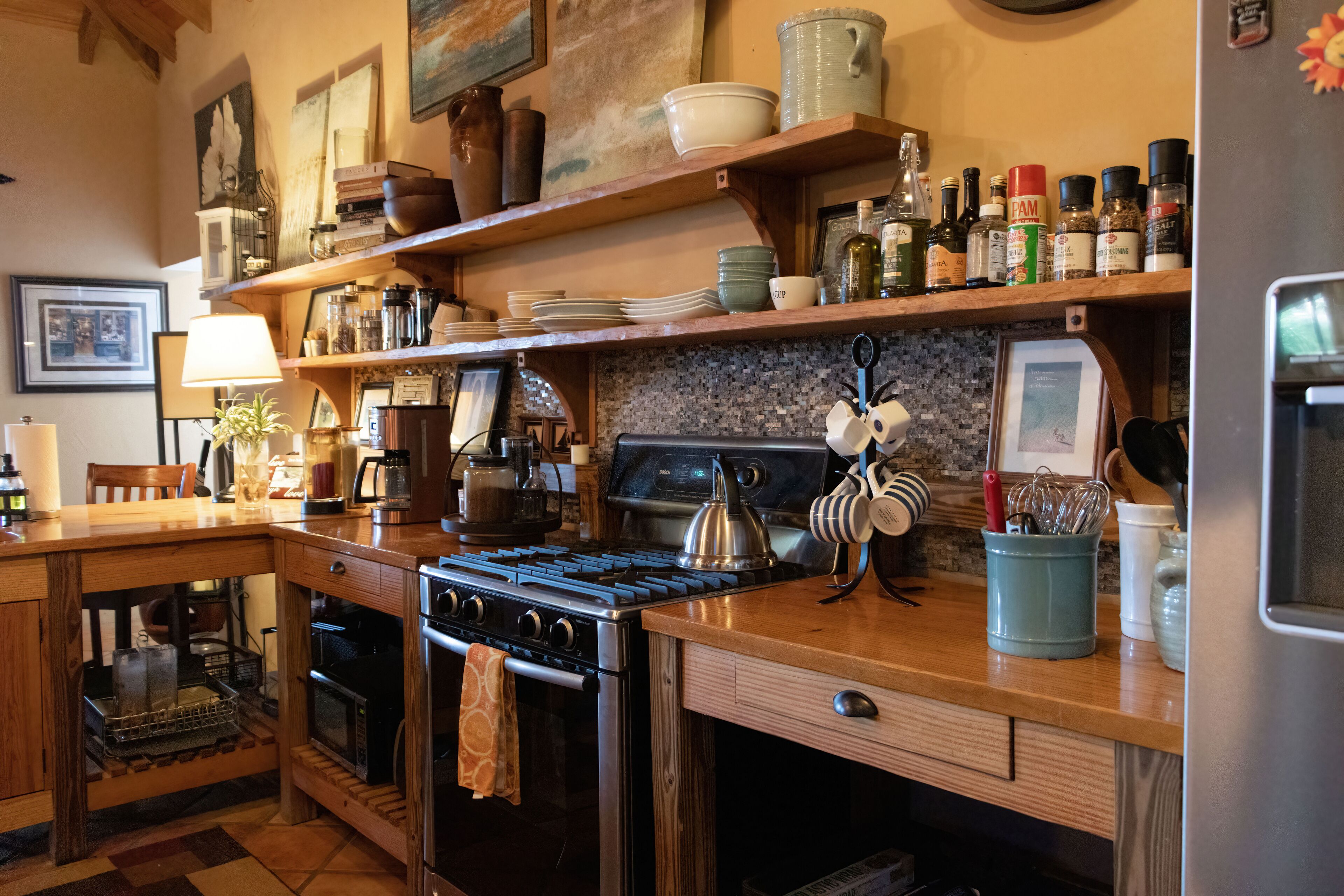 A kitchen with a stove, oven, and various kitchen utensils on the counter.