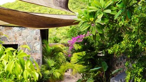 A covered outdoor area with potted plants and a stone wall.