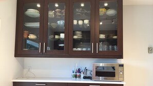 A kitchen with dark wooden cabinets, a microwave, and a white countertop.