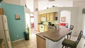 A kitchen with a central island, a microwave, and a stove. - 4BR Pool & Spa Home, Sleeps 8 – Near Disney, Clermont FL (Clermont)