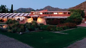 A modern building with a pool, surrounded by landscaped gardens and mountains in the background. - Grayhawk Mountain Views! Highly desirable Tesoro unit! (Scottsdale)