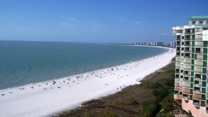 Une plage avec un grand bâtiment situé à côté.