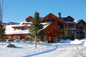Ein großes Holzhaus mit mehreren Zimmern und einer überdachten Veranda.