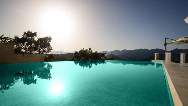 Une piscine aux eaux cristallines, avec une vue sur les montagnes en arrière-plan.