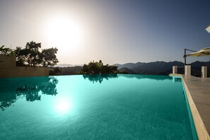 Una piscina cristalina con vistas a montañas al fondo.