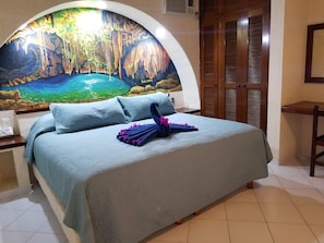 Relax in a serene space with a forest mural, a comfortable bed, and a stylish nightstand.