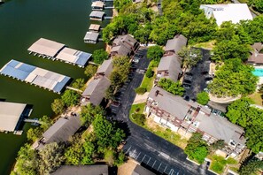 Vista aérea de un área residencial con casas, un estacionamiento y un muelle con barcos.