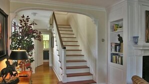 A staircase with white railings and wooden steps, leading to an upper floor. - Autumn House Shoreby Hill Jamestown Village  Pool, 5 Bdrms, Central Air, Office (Jamestown)