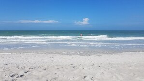 Une plage de sable blanc aux eaux calmes.
